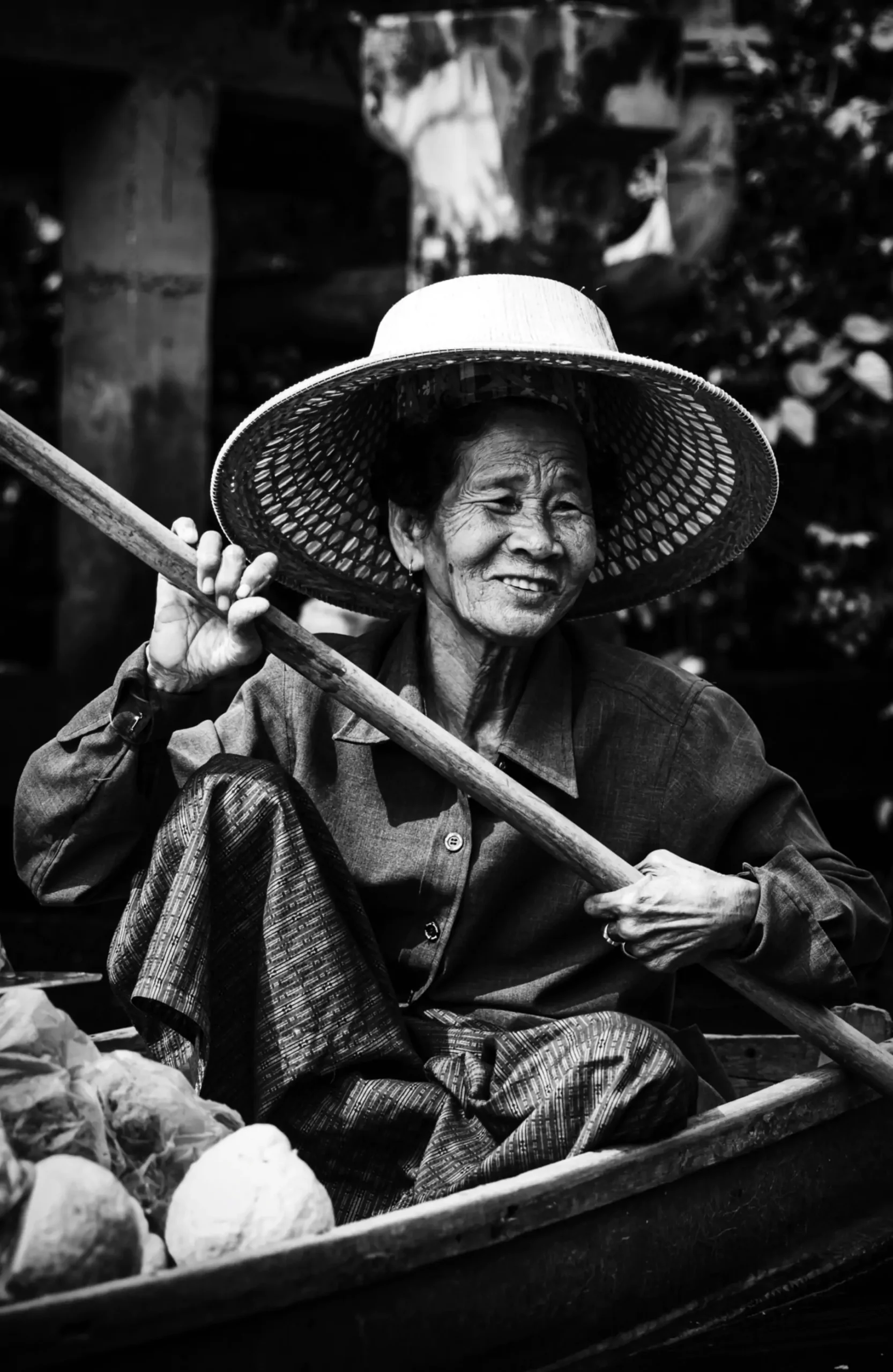 Thai elder selling fruits from a boat at floating market
