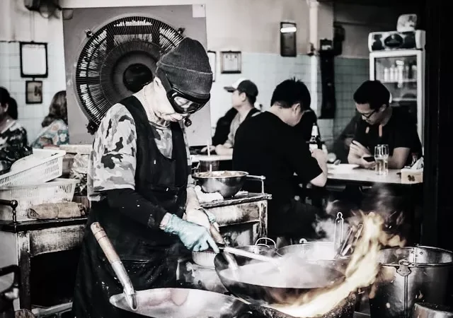 Jea Fai is cooking her high heat wok