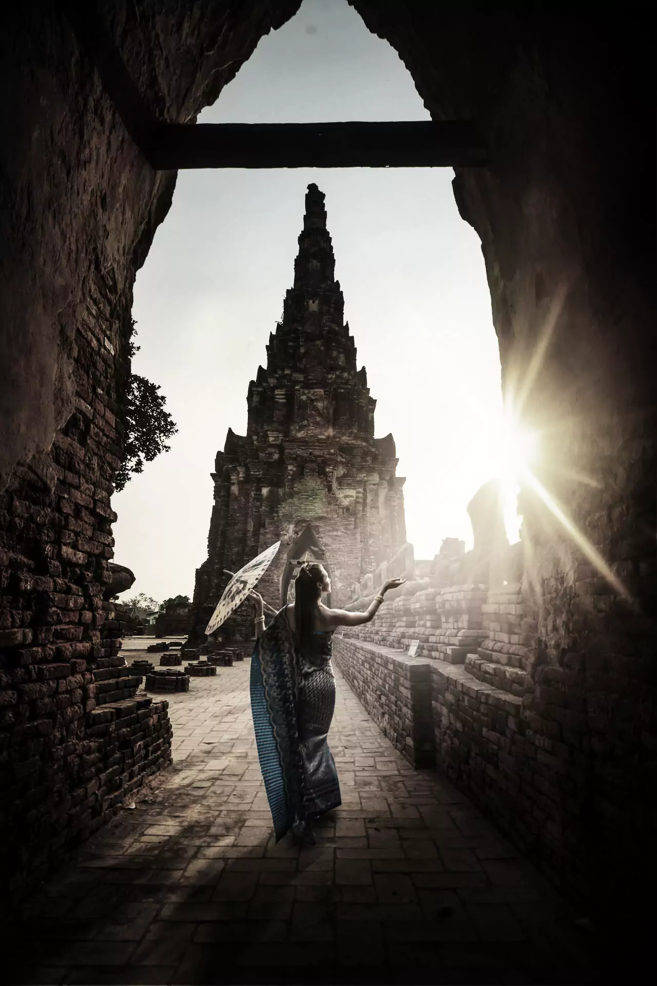 A beautiful Thai woman in traditional national costume walking gracefully through the ancient ruins of Ayutthaya, beautifully representing Thailand's past and living cultural heritage.