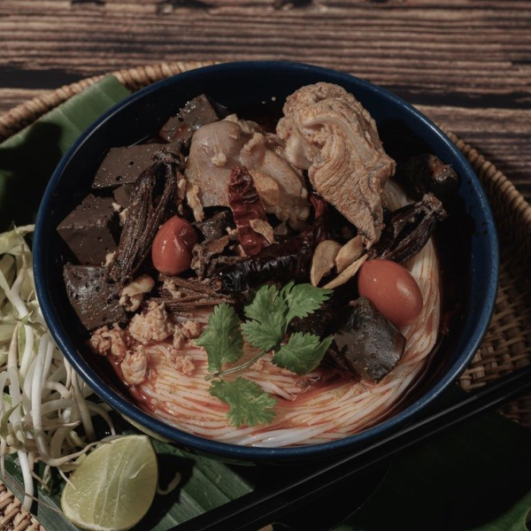 a vibrant bowl of Khanom Chin Nam Ngiao, a Northern Thai noodle soup