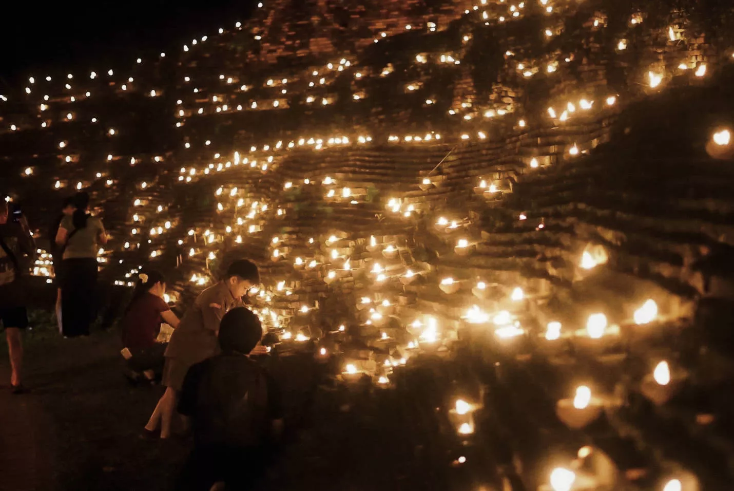 Thousands of phang pratheep clay oil lamps lit along the city moat